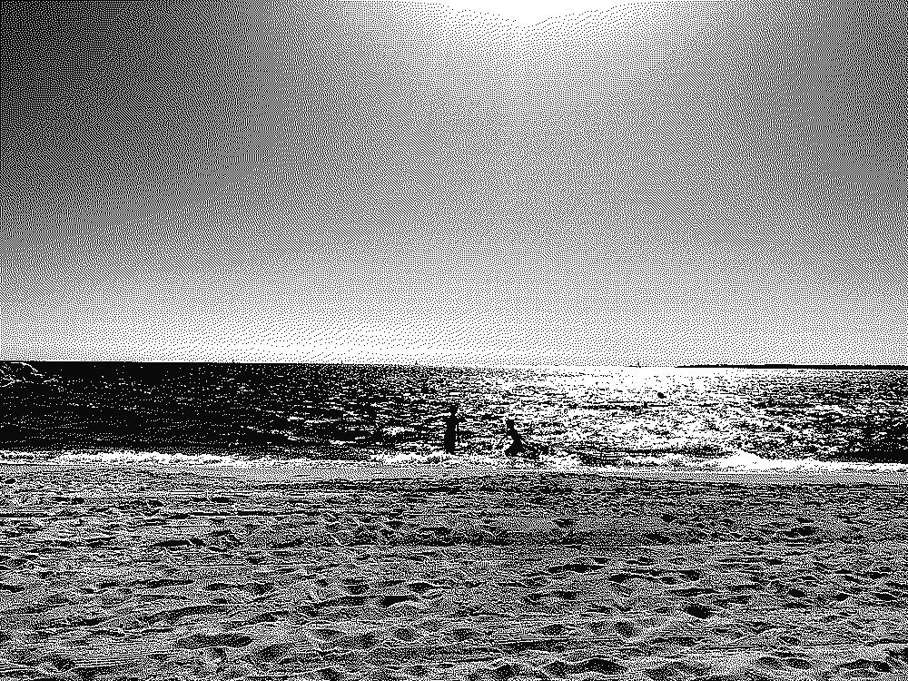 An empty sandy beach, two swimmers in bright sunlit sea